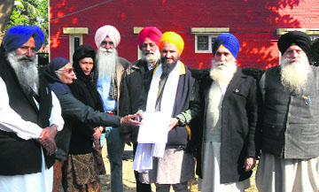 Bhai Gurbaksh Singh Khalsa and other members of Sikh Bandi Rehai Morcha show the application for premature release of Sikh detainees, in Mohali on Saturday.