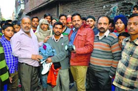 Residents who gathered after the death of the MC worker in a manhole at Abdulapur Basti in Ludhiana on Saturday