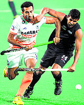 Dharamvir Singh (left) and New Zealand's Arun Panchia vie for the ball at Major Dhyan Chand National Stadium