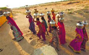 Women carry pitchers to fetch drinking water in the arid region of Rajasthan