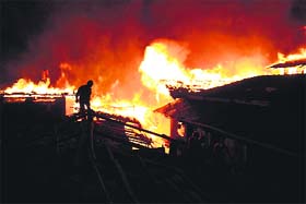 A firefighter tries to douse the fire that engulfed Dukezong town in China on Saturday