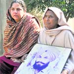 (Left) Beant Kaur (wife) and Ranjeet Kaur mother show the photo of Paramjit Singh in Bathinda. 