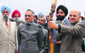 UT Adviser KK Sharma takes an aim at the bulls eye while Administrator Shivraj V Patil looks on.