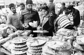 People purchase eatables for Lohri at a market in Phase V, Mohali, on Sunday.