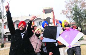 Young boys gesture as they fly kites during the Lohri festival in Amritsar on Monday