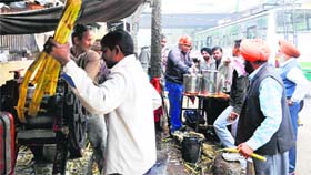 Residents wait for their turn at the sugarcane juice stall near Ram Bagh on Lohri in Amritsar
