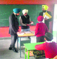 Chairman of the Zila Parishad, Bathinda, Gurpreet Singh Maluka, checks notebooks of the students during his surprise visit to a government school on Monday.