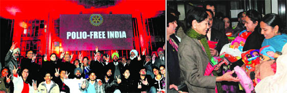 (Left) Members of the Rotary Club celebrate outside the illuminated Neelam Cinema in Sector 17, Chandigarh, on Monday; and members of the club distribute gifts among newborn girls on the eve of Polio Free Day at the General Hospital, Sector 6, Panchkula.