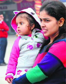 A woman, along with her child, braves the chill at Sector 17 in Chandigarh on Monday.
