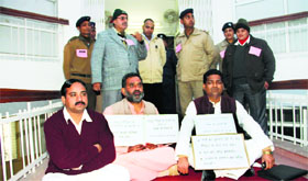 Three BJP legislators sitting on a dharna in support of their demands outside the state Assembly on the opening day of the session in Dehradun on Monday.