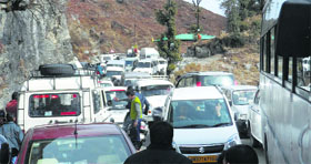 Tourists caught in a long traffic jam at Dhanaulti near Mussoorie on Monday.