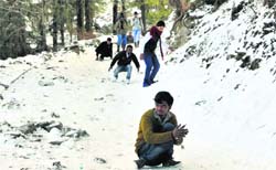 Tourists and locals play on frozen snow at Kufri on Monday. Photo: Amit Kanwar
