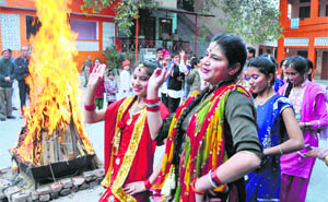 Girls dance around a bonfire during the Lohri celebrations at Geeta Bhawan in Jammu on Monday. 