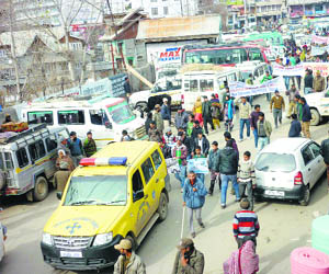 Volunteers carry banners and placards to create traffic awareness in Doda on Monday. 