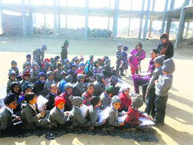 Students of Government Adarsh School, Middumaan, in Faridkot sit in the open in front of a partially constructed building on Monday.