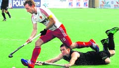 New Zealand's Phil Burrows tries to tackle England captain Barry Middleton during their last pool match of the Hockey World league Final in New Delhi on Monday. tribune photo