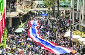 Anti-government protesters march with a giant Thai national flag in Bangkok on Monday