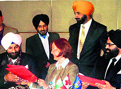 Cabinet minister Bikram Singh Majithia (left) exchanges MoU with premier of the Canadian province of Alberta Alison Redford (centre) in Amritsar