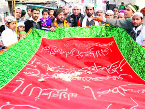 Devotees offer a chaddar at Piran Kaliyar in Haridwar on Tuesday on Eid-e-Milad-un-Nabi. 