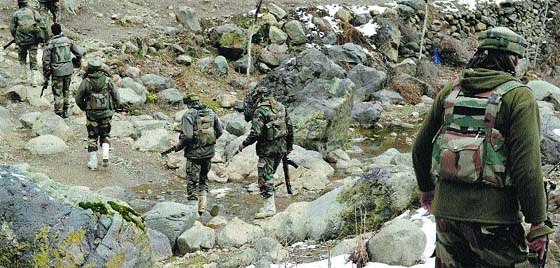 Army personnel carry out a search operation at the Charhar forest area of Sopore in Baramulla district on Tuesday. A Tribune Photograph