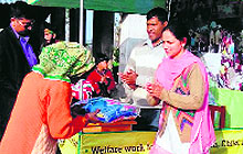 Rajpreet Kaur, Secretary of Versa, a voluntary organisatioon, distributes blankets among poor and needy persons at Pantgotal village in Udham Singh Nagar district on Wednesday