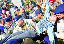 Policemen take an injured protester to hospital