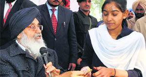 Chief Minister Parkash Singh Badal gives a cash prize of Rs 3,000 to a student in Lambi on Wednesday.