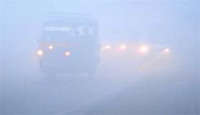 Vehicles move at a snails pace with headlights on in Amritsar on Thursday