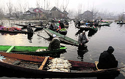 Vendors wait for customers at the floating vegetable market on the Dal Lake on a chilly Thursday morning in Srinagar