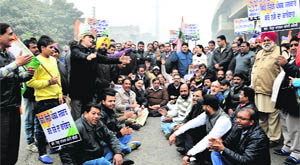 Congress workers stage a protest against Revenue Minister Bikram Singh Majithia at Jalandhar bypass in Ludhiana on Thursday. 