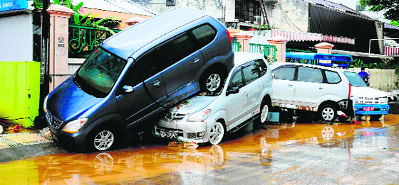 Cars are seen on top of each after being hit by flood waters in Manado city in Indonesia on Thursday. At least 16 persons have been killed and 40,000 have fled their homes after torrential rain triggered flash floods and landslides on Sulawesi island.