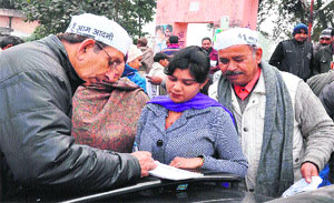 A woman being helped by Aam Aadmi Party volunteers in enrolling her as a member of the party in Haridwar on Friday.