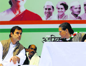 Congress president Sonia Gandhi talks to party vice-president Rahul Gandhi during the All-India Congress Committee meeting in New Delhi on Friday. 