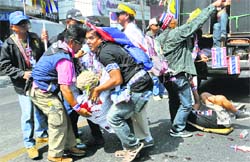 Protesters help the injured at the blast site in Bangkok on Friday. AFP