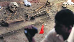 A police officer takes a video of human skeletons at a site that used to be in the war zone in Mannar near Colombo. Reuters