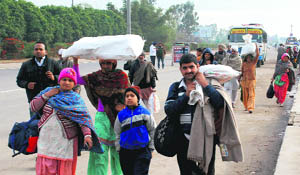 Commuters walk towards their destination after a Haryana Roadways bus dropped them far away from the Zirakpur flyover on Saturday.