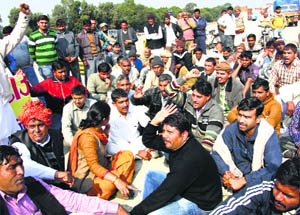 Villagers hold a protest at the toll plaza in Makdauli village on Sunday. 