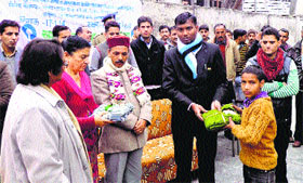 DC KS Vasant gives sweaters to children at Mehla in Chamba.