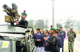 Schoolchildren observe the functioning of a missile firing vehicle in Fazilka on Sunday