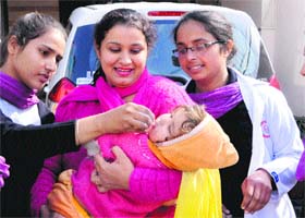Health officials administer polio drops to a child in a door-to-door campaign in Amritsar on Monday
