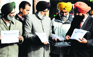 Employees distribute pamphlets to inform colleagues about the protest at Punjab Agricultural University in Ludhiana on Monday. 