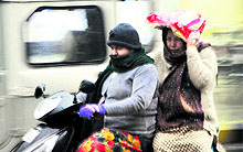 A spell of rain catches residents, travelling on a two-wheeler, suddenly in Amritsar on Tuesday