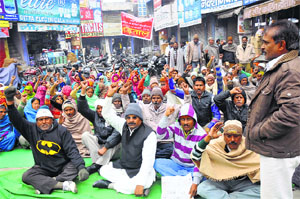 Employees of the Municipal Corporation shout slogans against the government during the second day of their strike in Karnal on Tuesday. 