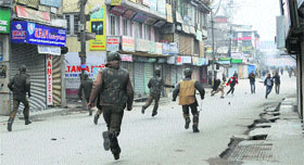 Youths throw stones at security forces during a shutdown call in Srinagar on Tuesday.