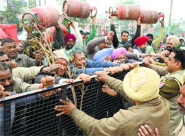 CITU workers carry LPG cylinders during a protest in Ludhiana on Tuesday. 