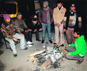 People around bonefire in Dehradun on Wednesday. 