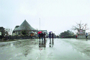 People walk with umbrellas during rain on The Ridge in Shimla on Wednesday