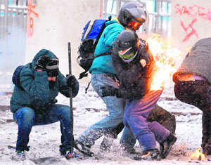 Protesters clash with the police in the centre of Kiev on Wednesday. Ukrainian police stormed protesters' barricades in Kiev as violent clashes erupted, leaving three dead