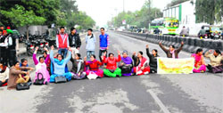 Guest faculty members of Government Rajindra College block the road during their strike in Bathinda on Thursday. Tribune photo: Pawan Sharma