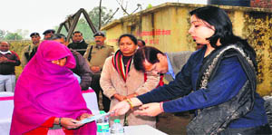 District Magistrate Nidhi Pandey hands over MNREGA job card to a resident of Pherupur village in Haridwar on Thursday.